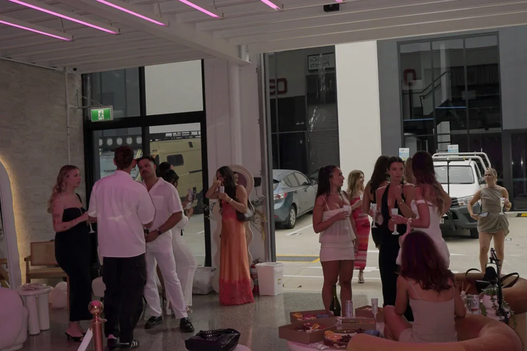 Wide view of the venue with guests, lounges and neon ceiling