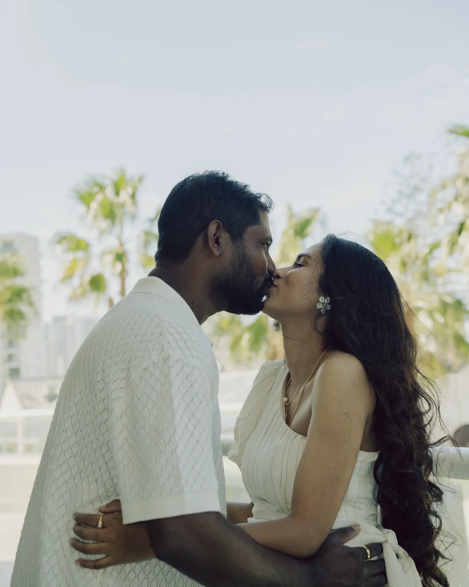 A couple close together in daylight on a balcony